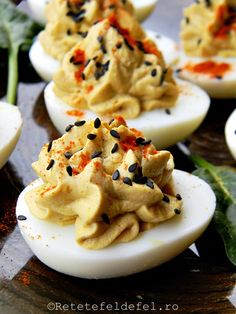 deviled eggs with sprinkles and black pepper on them