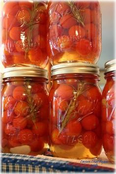 several jars filled with tomatoes sitting on top of a table