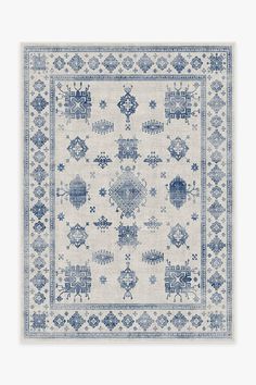 a blue and white rug with an intricate design on the bottom, in front of a light gray background