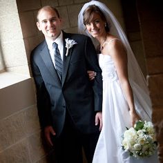 a bride and groom posing for a photo in front of a window at their wedding