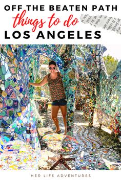 a woman standing in the middle of a park filled with lots of colorful glass tiles