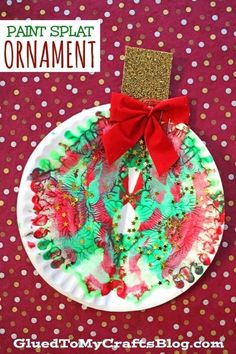 paper plate ornament with red bow on top and gold glitters around it