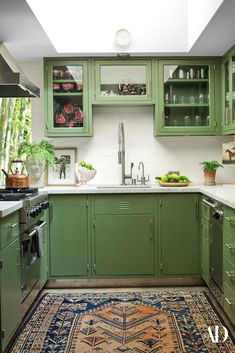 a kitchen with green cabinets and rug in the middle of the countertop area,