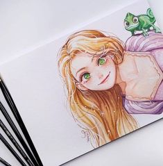 a drawing of a girl with green eyes next to some pencils and watercolor paints