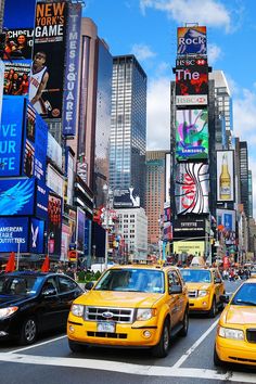 taxis, cars and billboards in new york city's times square on a sunny day