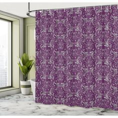 a purple shower curtain hanging in front of a window