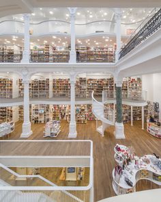 the interior of a large library with many bookshelves and staircases in it