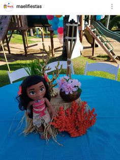 a doll sitting on top of a table next to a basket filled with corals