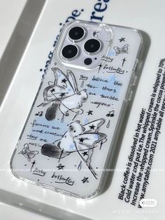 an iphone case with drawings on it sitting on top of a white table next to a package