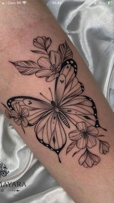 a black and white butterfly tattoo on the arm