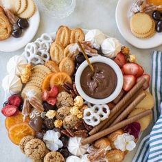 a platter filled with cookies, crackers and fruit