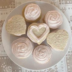 cupcakes with frosting in the shape of hearts on a plate