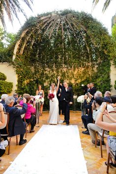 a bride and groom walking down the aisle after their wedding ceremony in an outdoor setting