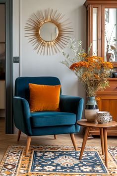 a living room with a blue chair and orange flowers on the coffee table in front of it