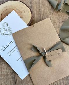 the wedding stationery is wrapped in brown paper and tied with a green satin ribbon