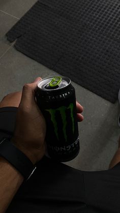 a man holding a can of monster energy drink