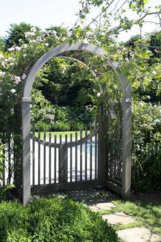 a wooden gate surrounded by lush green bushes