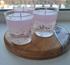 two candles are sitting on a wooden tray