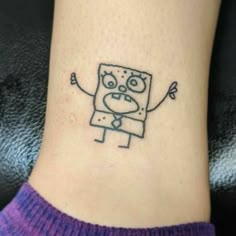 a small tattoo on the ankle of a woman's foot with a cartoon character drawn on it