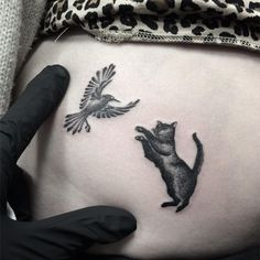 a cat and bird tattoo on the side of a pregnant woman's stomach,