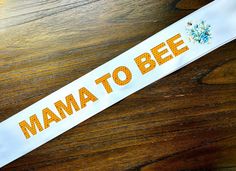 a sticker that says mama to bee on it sitting on top of a wooden table