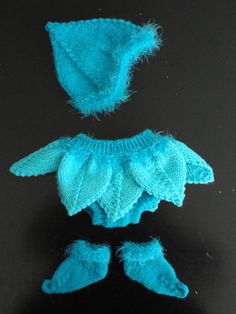 a blue knitted hat and booties on a black surface