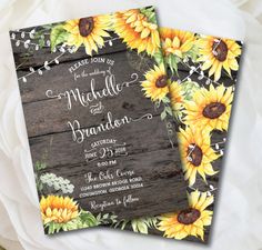 two sunflowers and greenery are on top of the rustic wood wedding stationery