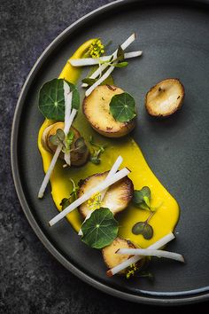 a black plate topped with food on top of a table