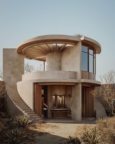 a round building with stairs leading up to it's top floor and an open patio area