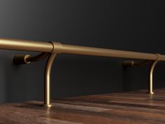 a close up of a metal bar on a wooden table with black background and gold accents