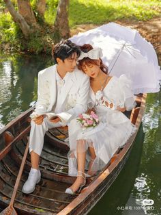 two people sitting in a boat with an umbrella