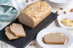 a loaf of bread sitting on top of a cutting board next to slices of bread