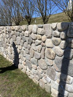 a stone wall with trees in the background