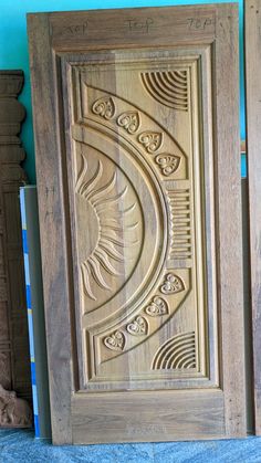 an intricate carved wood panel on display in a room with blue walls and flooring