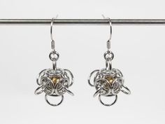 A pair of chainmaille drop earrings with a Tetra Orb weave. The earwires and the jump rings are made of 316 stainless steel. You can choose between regular Tetra Orb earrings or with captured beads (bearing balls). For the bearing balls you can choose between brass and stainless steel.The jump rings are 18swg (1.2mm) thick. The earrings are 1 3/4" (4.4cm) long. The regular earrings weigh 0.14oz (3.9g) each. The earrings with bearing balls weigh 0.19oz (5.4g) each.The earrings will be shipped tog Silver Dangle Earrings With Box Chain, Metal Earrings With Box Chain For Gift, Chainmaille Ring, Chainmail Ring, Orb Earrings, Chainmail Earrings, Biker Chain, Chain Belts, Ball Earrings