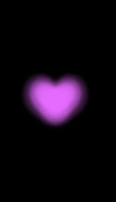 a heart shaped object in the dark with pink light coming from it's center