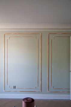 an empty room with some paint rollers on the floor next to it and walls painted white