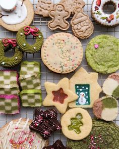 many decorated cookies and pastries on a cooling rack