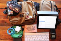 an assortment of personal items laid out on a wooden floor next to a laptop computer