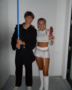 a man and woman dressed up as star wars characters holding lightsabens in their hands