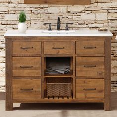 a bathroom vanity with two sinks and a basket under the faucet in front of it