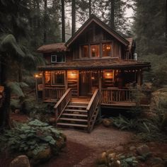 a cabin in the woods with stairs leading up to it's front door and lights on