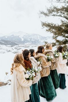 a group of women standing next to each other on top of a snow covered field