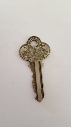 an antique key with the word'welcome home'written on it is shown in front of a white background