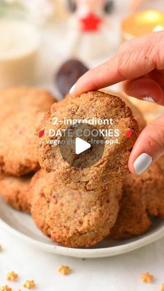 a person is picking up some cookies from a plate