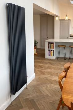 a kitchen with a large radiator next to a dining room table