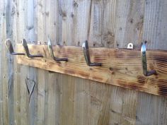 a coat rack made out of wood and metal hooks