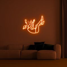 a living room with a couch and a neon sign on the wall