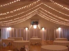 the inside of a banquet hall with tables and chairs covered in white draping