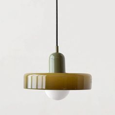 a green and white pendant light hanging from a ceiling fixture with a black cord attached to it